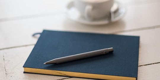 Blue journal and pen, cup of coffee. 
