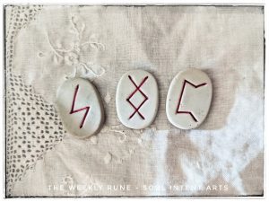 The elder futhark runes Perthro, Ingwaz, and Sowilo on a white linen background