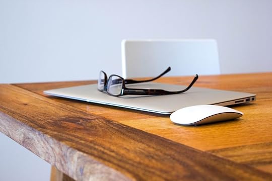 A pair of glasses placed on top of a closed laptop computer.
