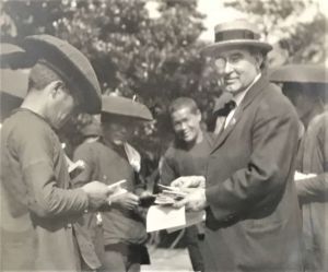 Charles Cowman handing out tracts in Seoul, 1907