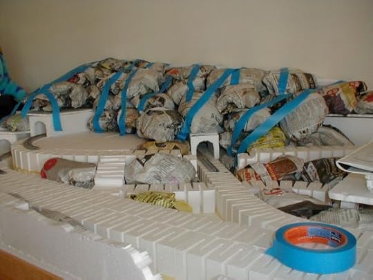 photo of a model railroad under construction including balled up newspaper to form mountains