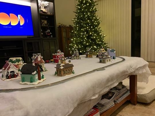 Small n-scale train around a Christmas village on a coffee table