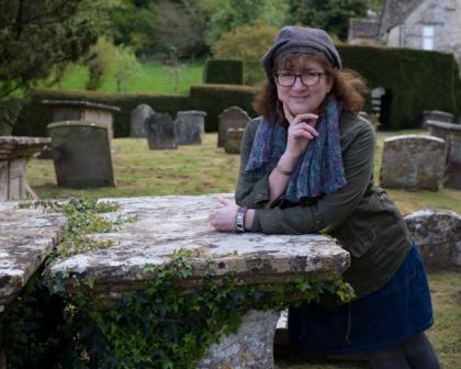 Photo of Debbie smiling in a graveyard
