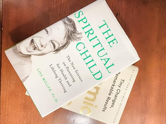 photo shot looking down at stack of books on a table with the book The Spiritual Child on top