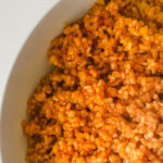 closeup of Spanish brown rice in white bowl.