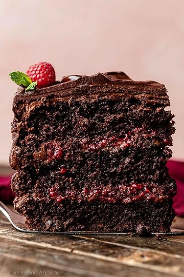 slice of 3-layer chocolate raspberry cake with chocolate raspberry ganache and raspberry filling.