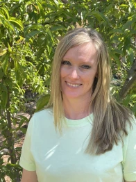Photo of Robbie Cheadle standing in front of trees.