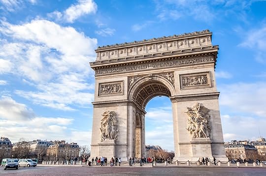 The famous Arc de Triomphe against nice blue sky. The Arc de Triomphe monument at at the western end of the Champs-Elysées road in Paris, France