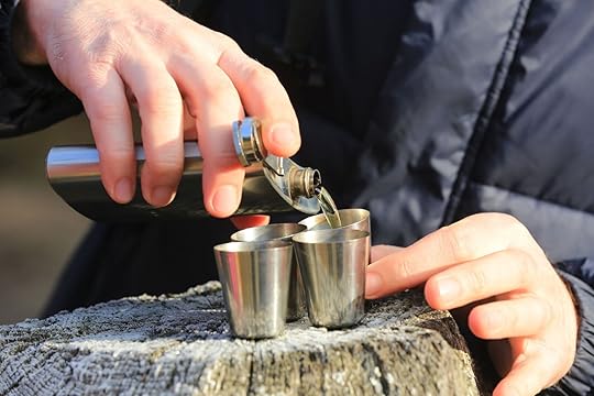 man pouring whiskey at a campsite