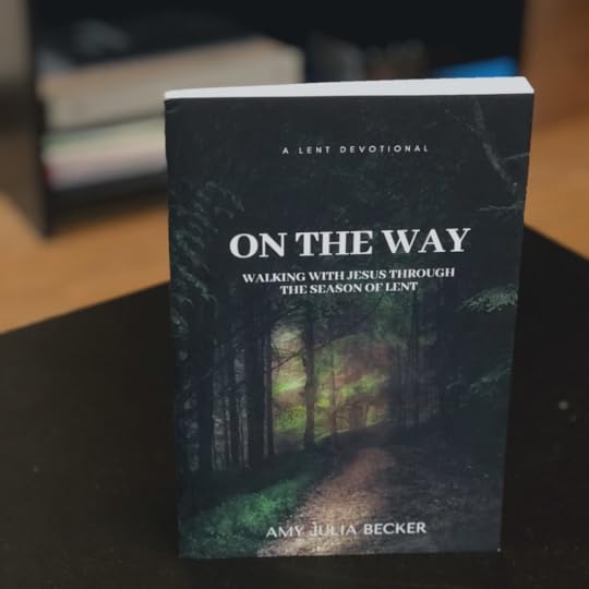 photo of the devotional On the Way: Walking with Jesus Through the Season of Lent on a black table with a bookshelf blurred in the background