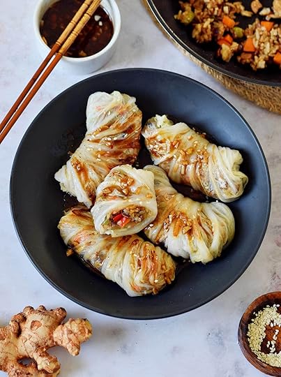 vegan cabbage rolls in black bowl with Chinese garlic sauce