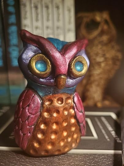 A small metallic owl sculpture. Painted with metallic acrylic paints including copper, bronze, teal, berry, and purple.