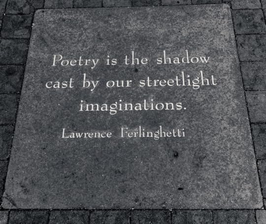 Photo of a Lawrence Ferlinghetti quotation seen on the street that says: Poetry is the shadow cast by our streetlight imaginations.