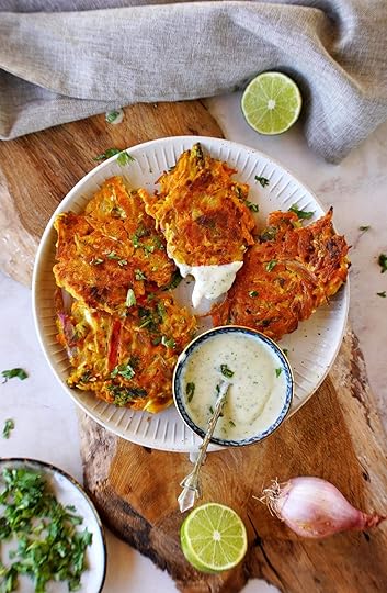 top shot of 4 vegetable pakora on white plate with raita dip