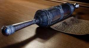 A close-up color photo of the silver case of the scroll, showing the fine silverware of its handle