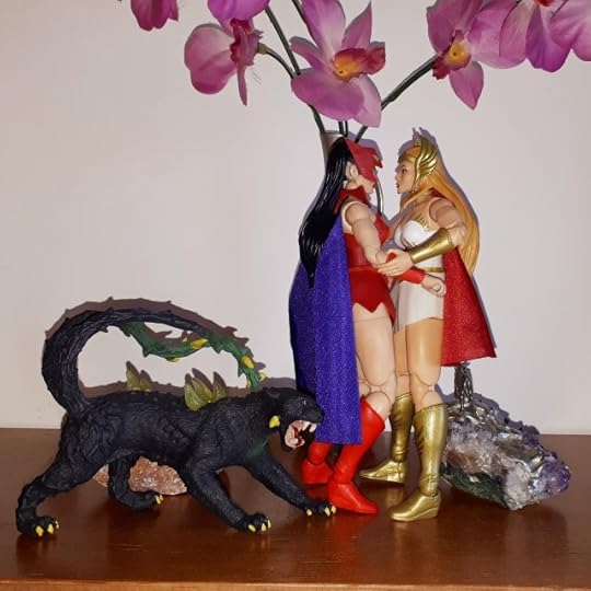 Catra and She-Ra kiss, while Catra's panther looks on.