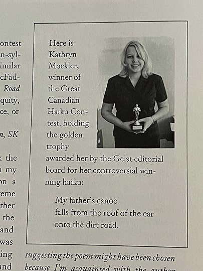 Kathryn Mockler holding the golden trophy with a big smile on her face.