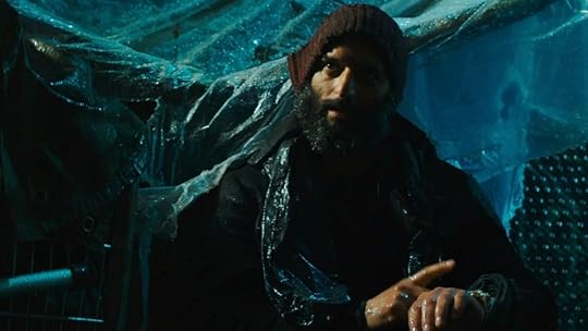 Jason Mantzoukas dressed an unhoused man sitting in the rain tapping his watch in John Wick: chapter 3