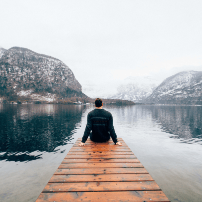 man-on-pier-facing-water