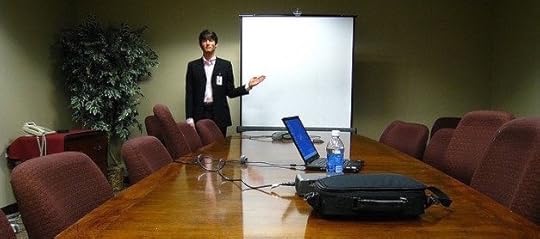 Entrepreneur pitching in front of a screen in a conference room.