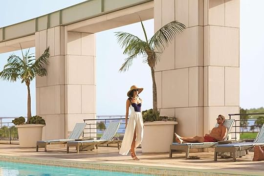a woman walking near the pool and another person in a lounger by the outdoor pool at the Manchester Gran Hyatt in San Diego