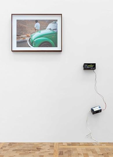 Color photograph of an exhibition with a photograph and a taxi meter