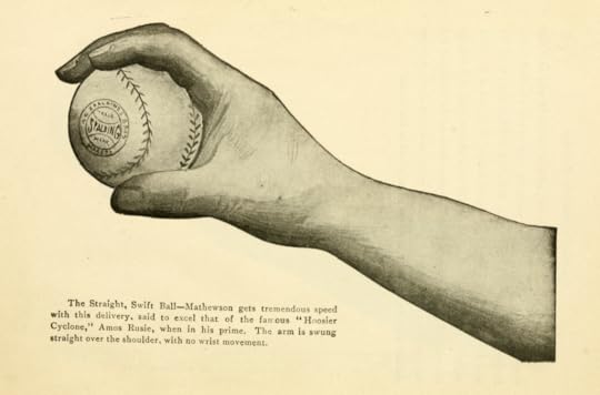 Side view of a hand holding a baseball across the seams