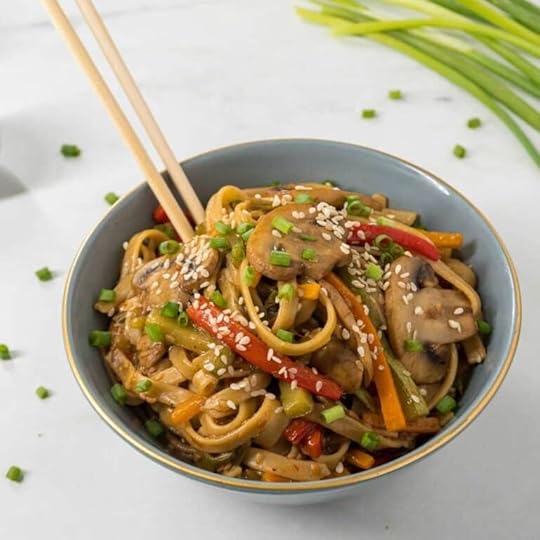 Asian Vegetable Pasta in a blue bowl with a pair of chopsticks dug into the noodles.