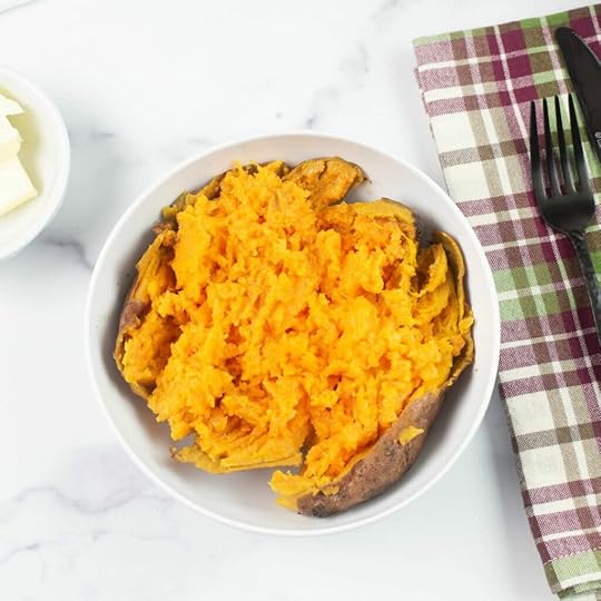 A crock pot baked sweet potato split open in a bowl.