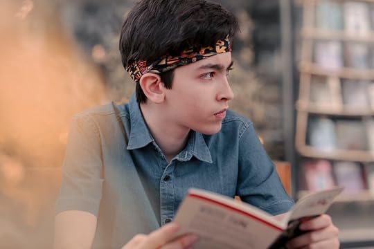 A young boy holding a book in his hands.