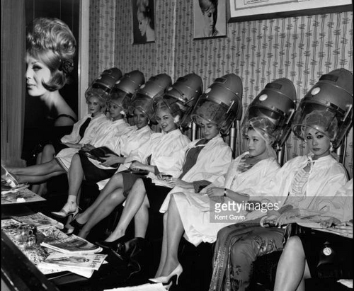 women sitting under hood dries