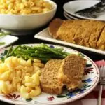 dinner plate with mac and cheese, meatloaf, and green beans.