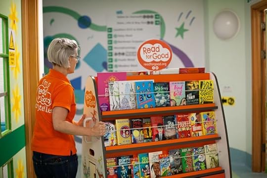nurse pushing Read for Good mobile bookcase in hospital