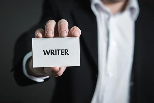 Image: a man wearing business attire holds forth a business card printed with just the word 