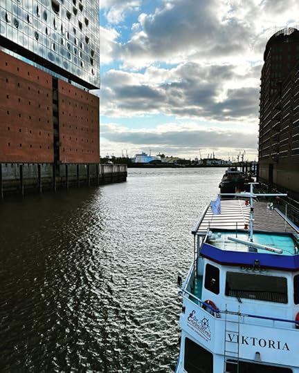 Seitlicher Blick auf den unteren Teil der Elbphilharmonie, im Vordergrund ein Schiff namens 