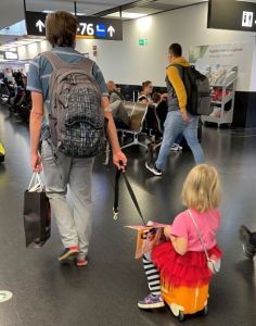 Child riding on a suitcase as a travel hack