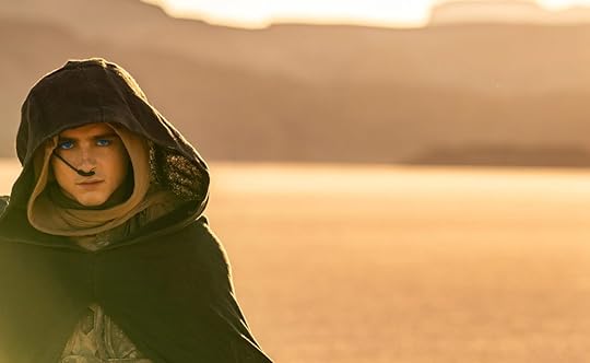 Paul Atreides, eyes spice blue, stands alone in the desert