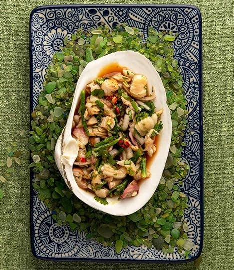 Clam ceviche served in the shell on a bed of green sea glass.