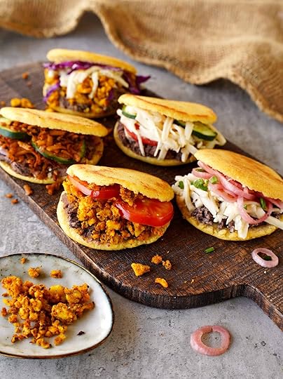 6 arepas on wooden board with healthy fillings