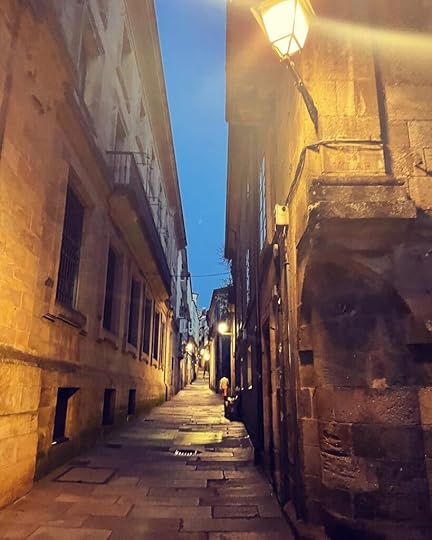 an alleyway stretching into the distance, everything hued in yellow from the lamplight