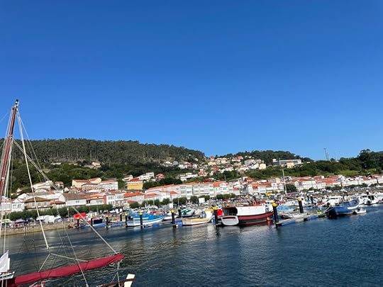 Muros, a fishing village on the coast of Galicia, is made up of bright white and red buildings, archways, and nearly hundreds of bright boats sit bobbing in the water