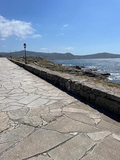 Dark mountains in the background, the foreground a smooth stone pathway with stone railings dotted with lamps
