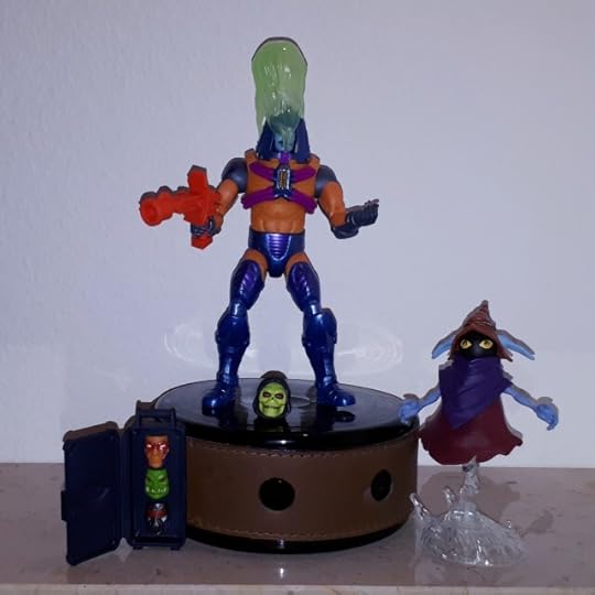 Man-e-Faces wears the Keldor face covered in acid, while Orko looks on.