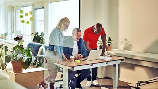Office image with employees surround a desk reading about the Work Opportunity Tax Credit WOTC