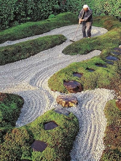 A Japanese Garden with a person maintaining the gravel with a rake