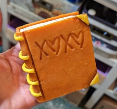 Bar of soap crafted to look like a little orange covered book, from Holiday Farm