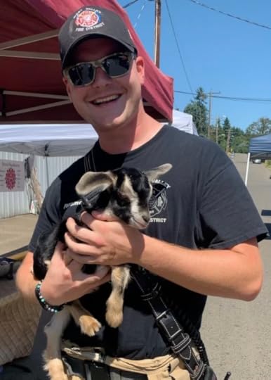 Firefighter holding a baby goat