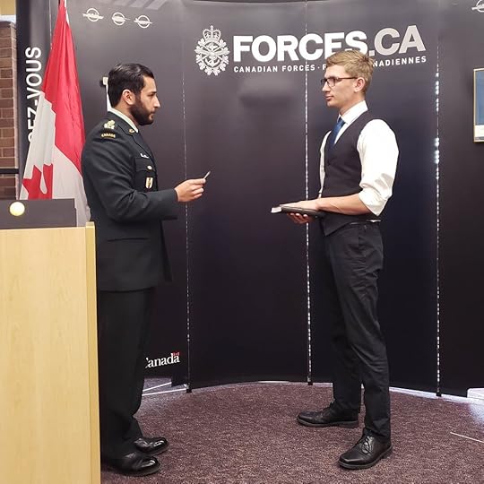 Jude has his hand on the Bible and stands before a military officer to say his oath of allegiance.