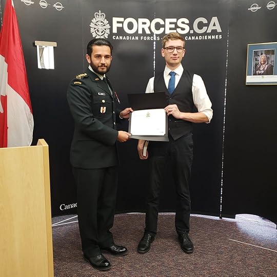 Jude and a military member holding Jude's new certificate.