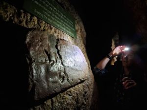 Man looks at the inscription inside Hezekiah's tunnel.